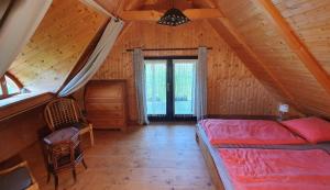 a bedroom with a bed in a wooden cabin at Traditional cottage at Lake Balaton in Vászoly