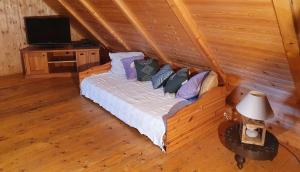 sypialnia z łóżkiem z poduszkami i telewizorem w obiekcie Traditional cottage at Lake Balaton w mieście Vászoly