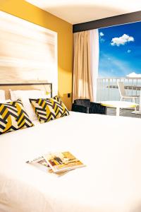 um quarto com uma cama e uma janela grande em Hotel Ker Moor Saint-Quay Portrieux em Saint-Quay-Portrieux