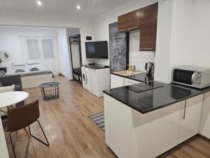 cocina y sala de estar con mesa y sofá en City Center Apartments, en Pafos