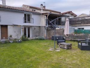 a yard with a house and an umbrella at Le petit nid in Montgaillard