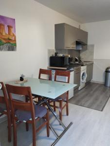 een keuken met een tafel en stoelen in een kamer bij Le petit nid in Montgaillard