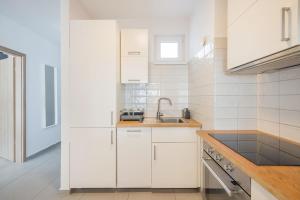 ブダペストにあるBright Top Floor Home with Terraceの白いキャビネットとシンク付きのキッチン