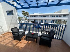 a balcony with chairs and a table and a building at Apartamento Olivin in Puerto del Carmen