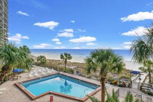 a view of the pool and beach from the balcony of a resort at Commodore 504 in Panama City Beach