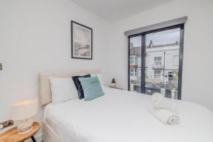 een witte slaapkamer met een groot bed en een raam bij Super Central 2 Bedroom Flat I Next to Brighton Station in Brighton & Hove