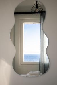 a mirror in a bathroom with a window at Olive & Sea Luxury Suites in Skala Sotiros +125 photos