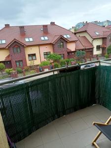 zielony płot na balkonie z budynkami w tle w obiekcie Ul Prusa Centrum 45m balkon dla 5 osób w mieście Piła