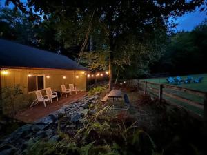 une tente avec une table et des chaises dans une cour la nuit dans l'établissement Spacious Catskills Home with Covered Hot Tub, à Monticello