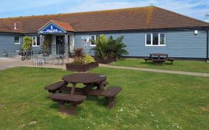 a picnic table in the grass in front of a building at The Oyster Shell in Whitstable