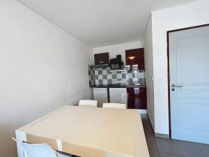 een witte tafel en stoelen in een kamer met een keuken bij 3303 - maison avec piscine in Argelès-sur-Mer