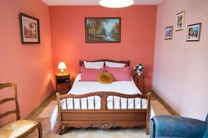 Schlafzimmer mit orangefarbenen Wänden und einem Bett mit rosa Kissen in der Unterkunft Jolie maison au calme - 300m de la plage - Terrasse - Barbecue in Saint-Michel-Chef-Chef