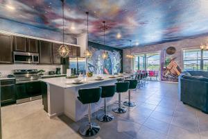 a kitchen with a long bar with stools in it at StarWar Retreat 3D 12BR 11.5BA Villa Pool BBQ in Kissimmee