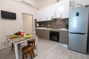 a kitchen with a table and a refrigerator at Stazione - Arno River apartment in Florence
