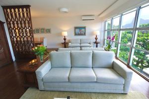 uma sala de estar com um sofá e janelas grandes em Apartamento vista mar e montanha no Rio de Janeiro