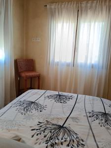 una camera da letto con un letto, una finestra e una sedia di EL BALCÓN PANORÁMICO DEL TIÉTAR a Mijares