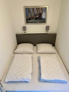 um quarto com duas camas com uma fotografia na parede em Fehmarn Ferienwohnung Weber Captains Corner Südstrand WHG 59-110 em Fehmarn