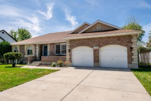 a house with two garage doors in a yard at Fully loaded, 12 beds, cool bunk room, hot tub! in Heber City
