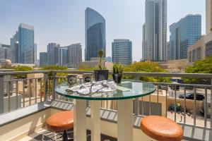 a glass table on a balcony with a view of a city at Frank Porter - Claren Tower in Dubai