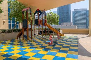 a playground with a checkered floor and slides at Frank Porter - Claren Tower in Dubai