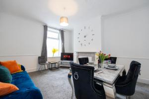 a living room with a blue couch and a table at Cosy Three Bedroom Terrace Rishton in Rishton