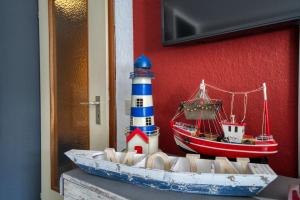 ein Modell eines Leuchtturms und ein Boot auf einer Theke in der Unterkunft Ferienpark - Haus C, App 0CEG06 in Heiligenhafen
