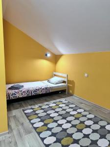 a bedroom with a bed and a rug on the floor at Гостевой Отель-125 in Aktau