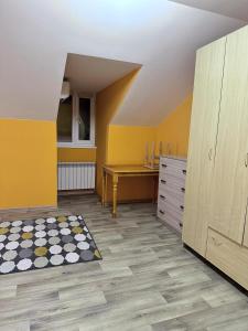a yellow room with a desk and a table at Гостевой Отель-125 in Aktau
