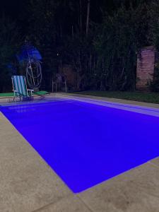 a blue swimming pool at night at Acogedor chalet a 5 minutos de las playas. in Mar del Plata