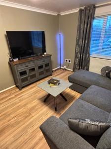 a living room with a couch and a flat screen tv at Modern Luxury apartment Liverpool in Liverpool