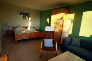 a room with a bedroom with a bed and a couch at Landhaus-Sutje-Im-Gruenen in St. Peter-Ording