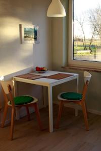 a small table with two chairs and a window at Landhaus-Sutje-Im-Gruenen in St. Peter-Ording