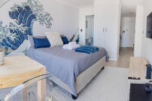 ケープタウンにあるBeach & Sea View Facing Apartment Japanese Styledの青い枕が付いた大きなベッドのある寝室