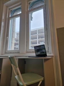 a laptop sitting on a desk next to a window at Luther Boutique Homes Downtown in Budapest