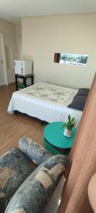 a room with two beds and a table and a couch at Pousada Floresta in Joinville