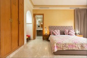 um quarto com uma cama com uma colcha rosa em Maison 3 chambres em Marrakech