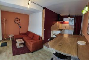 a living room with a couch and a table at Green Summer in Pont-d'Ouilly