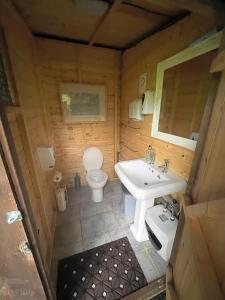 a small bathroom with a toilet and a sink at WoodLands Basic Bell Tent 3 in Grantham