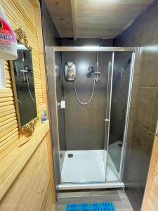 La salle de bains est pourvue d'une douche avec une porte en verre. dans l'établissement WoodLands Basic Bell Tent 3, à Grantham