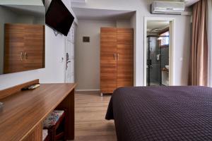 a bedroom with a bed and a dresser with a television at Aqua Princess Hotel in Kaş