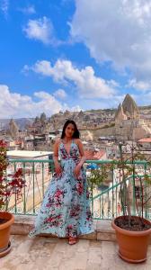a woman in a floral dress standing on a balcony at Gedik Cave Hotel in Goreme