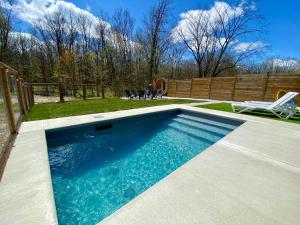 uma piscina com água azul num quintal em Kings Woods Lodge Resort in Wine Country with Heated Pool, Sauna & Games em Kingsville