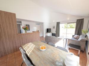 uma sala de estar com uma mesa e um sofá em Spacious holiday home with terrace em Zevenhuizen