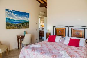 um quarto com uma cama grande e almofadas vermelhas em Casa Ulivo em Orbetello
