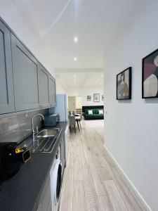 a kitchen with a sink and a washing machine at High-Spec Apartment in London - City Centre & Next To Tube in Ealing