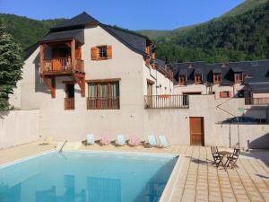 a house with a swimming pool in front of a building at Reflets montagnards in Vignec