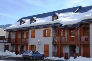 a car parked in front of a house with snow at Reflets montagnards in Vignec