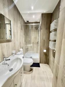 a bathroom with a toilet and a sink and a shower at High-Spec Apartment in London - City Centre & Next To Tube in Ealing