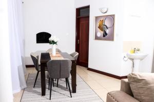 a dining room with a table and chairs and a sink at TANISHIA APARTMENTS in Mombasa