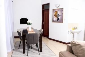 Un comedor con mesa y sillas y un fregadero. en TANISHIA APARTMENTS, en Mombasa